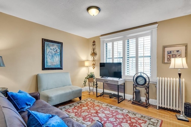 living room with radiator, wood-type flooring, and a textured ceiling