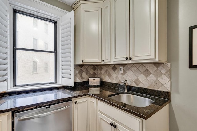 kitchen featuring dark stone countertops, sink, stainless steel dishwasher, and backsplash