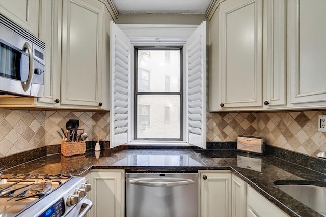 kitchen with dark stone countertops, sink, plenty of natural light, and stainless steel appliances