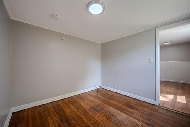 unfurnished room featuring wood finished floors, crown molding, and baseboards