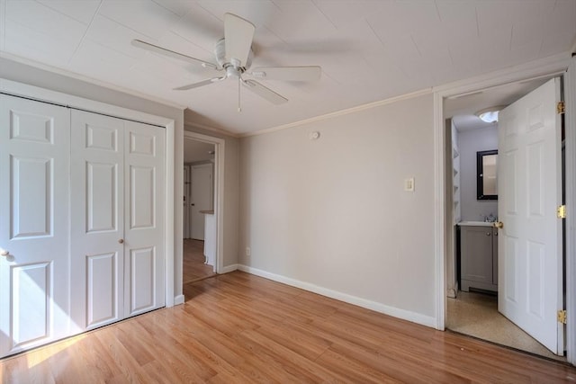 unfurnished bedroom with baseboards, light wood-type flooring, a closet, a ceiling fan, and crown molding