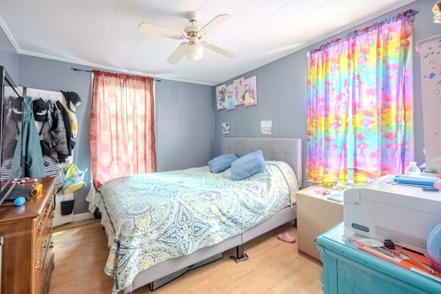 bedroom with wood finished floors, ornamental molding, and a ceiling fan