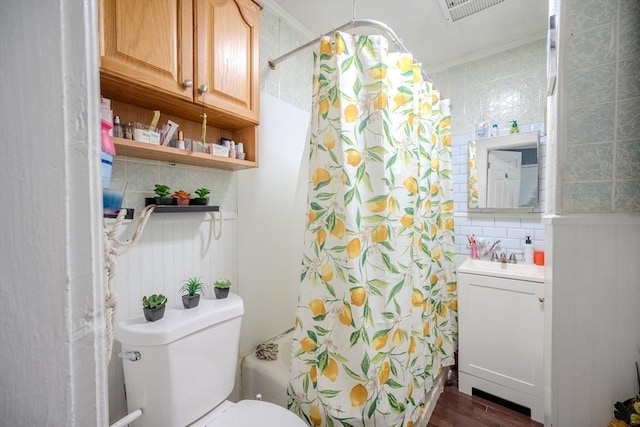 bathroom featuring toilet, wood finished floors, shower / tub combo, and vanity