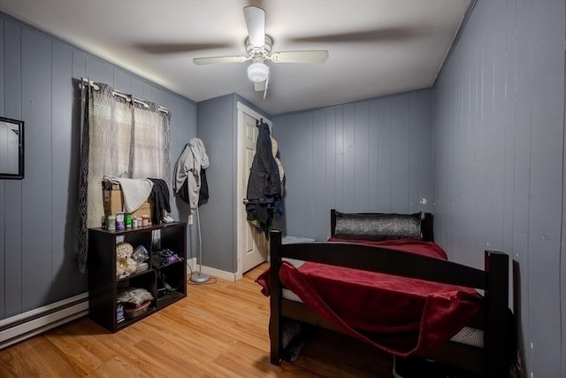 bedroom with light wood-type flooring, a baseboard radiator, and ceiling fan