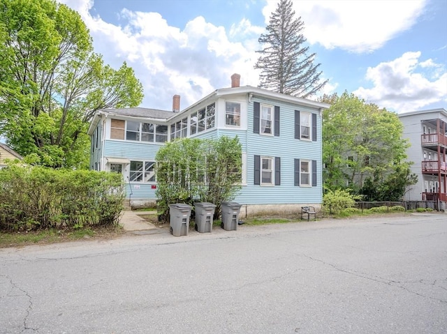 view of front of house featuring a chimney and a sunroom