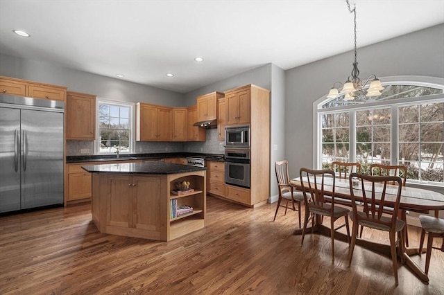 kitchen featuring built in appliances, under cabinet range hood, open shelves, dark countertops, and dark wood finished floors