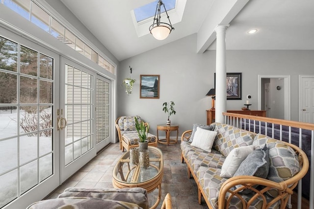 living area featuring french doors, decorative columns, recessed lighting, vaulted ceiling with skylight, and baseboards