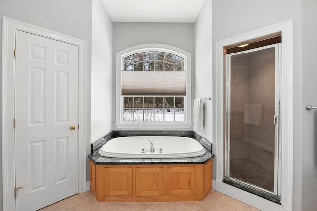 bathroom with a stall shower, tile patterned floors, and a bath