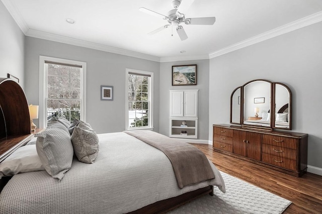 bedroom with baseboards, ornamental molding, ceiling fan, and wood finished floors