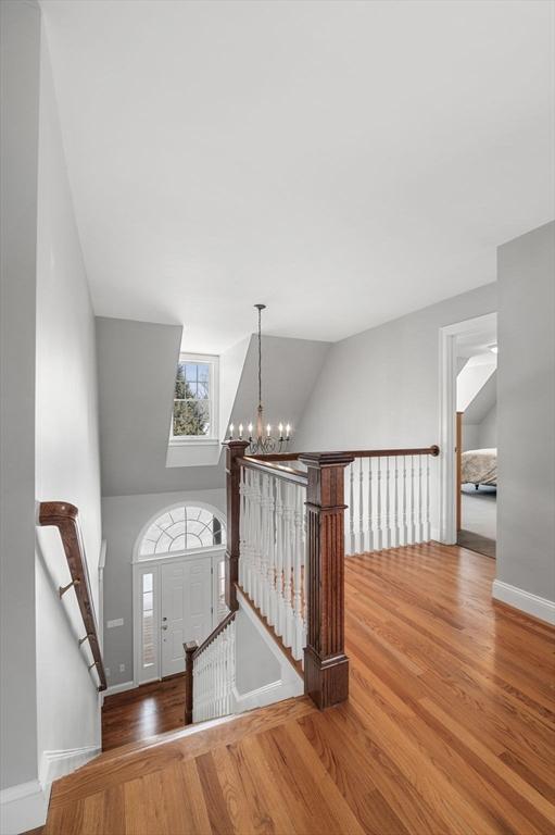 foyer featuring an inviting chandelier, baseboards, and wood finished floors