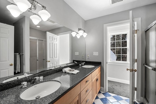 bathroom featuring visible vents, a sink, and a shower stall