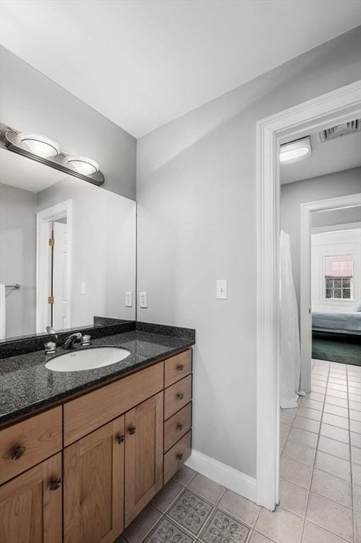 bathroom with baseboards, visible vents, vanity, and tile patterned floors