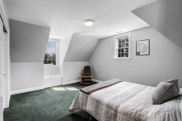 carpeted bedroom featuring lofted ceiling and baseboards