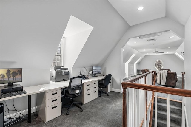 office space with a wealth of natural light, dark colored carpet, and vaulted ceiling