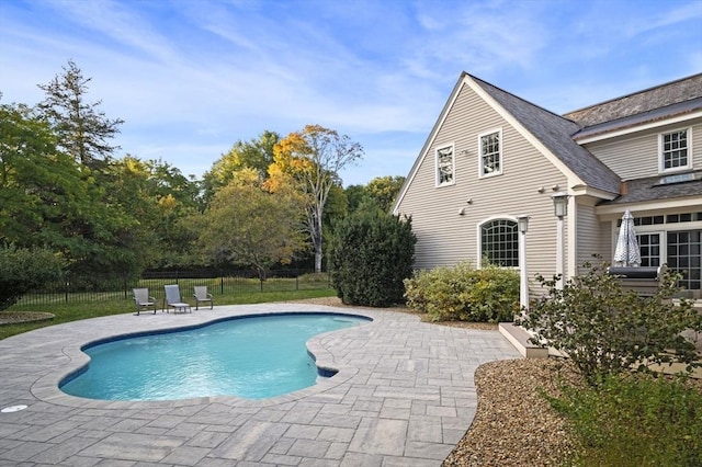 view of swimming pool with a patio area, fence, and a fenced in pool