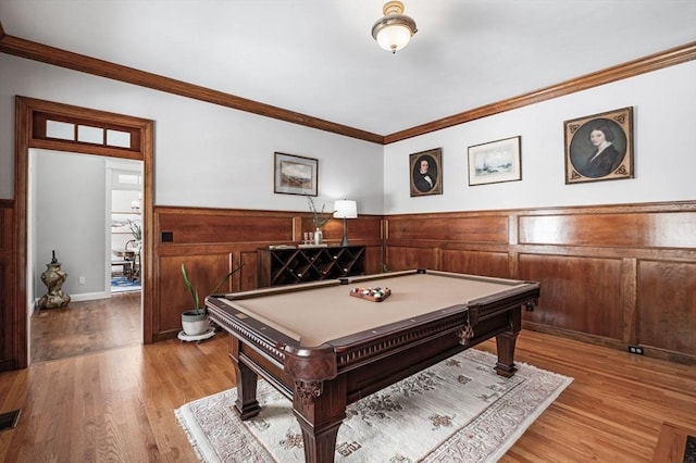 rec room featuring a wainscoted wall, crown molding, and wood finished floors