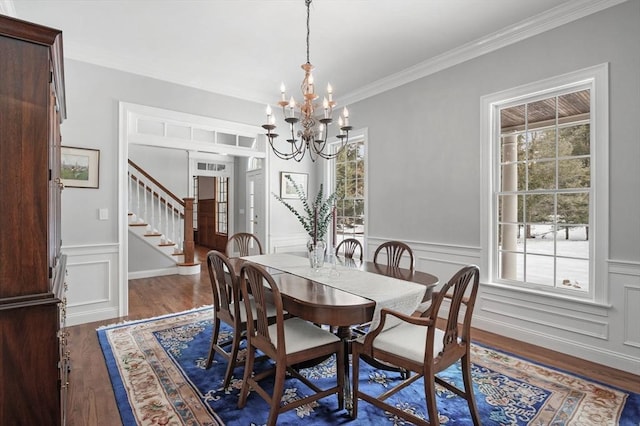 dining space featuring dark wood-style floors, stairs, a wealth of natural light, and an inviting chandelier