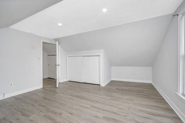 bonus room featuring lofted ceiling and light hardwood / wood-style flooring