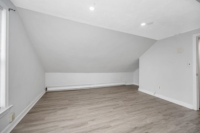 bonus room featuring hardwood / wood-style flooring, vaulted ceiling, and baseboard heating