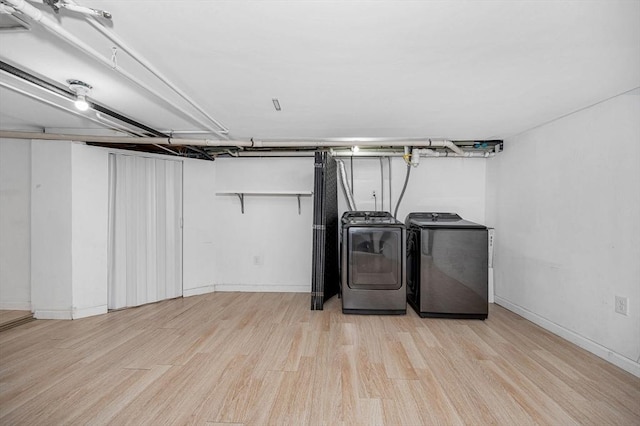 laundry room featuring independent washer and dryer and light hardwood / wood-style floors