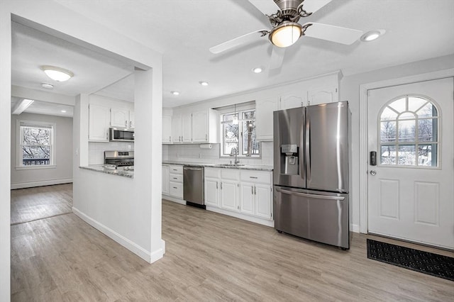 kitchen with white cabinetry, sink, a wealth of natural light, and appliances with stainless steel finishes