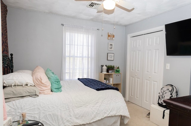 bedroom with ceiling fan, a closet, and light colored carpet