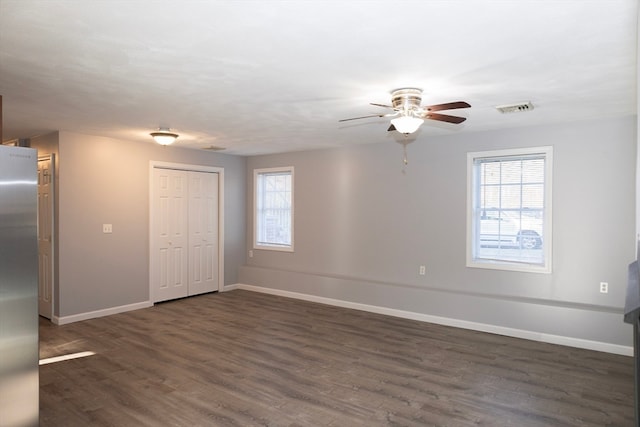 unfurnished room with dark hardwood / wood-style floors, ceiling fan, and a wealth of natural light