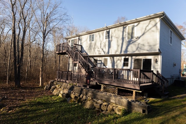 back of property featuring a lawn and a deck