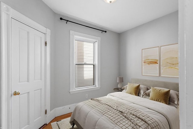 bedroom with baseboards and wood finished floors