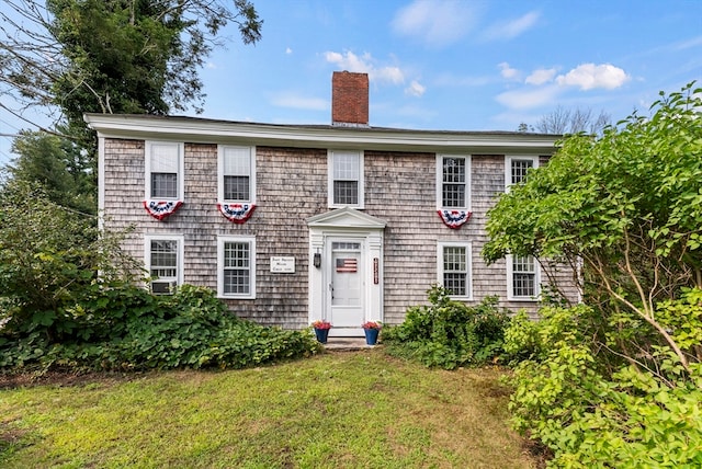 colonial-style house featuring a front yard