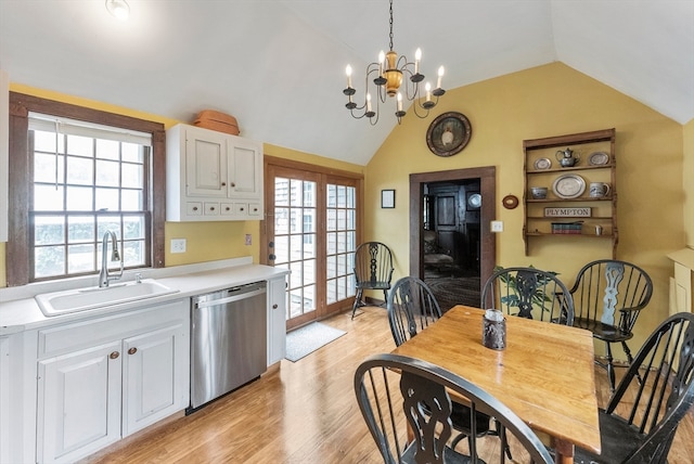 dining space featuring a wealth of natural light, vaulted ceiling, sink, and light wood-type flooring