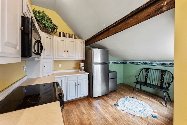 kitchen with vaulted ceiling with beams, range, light hardwood / wood-style floors, stainless steel fridge, and white cabinets