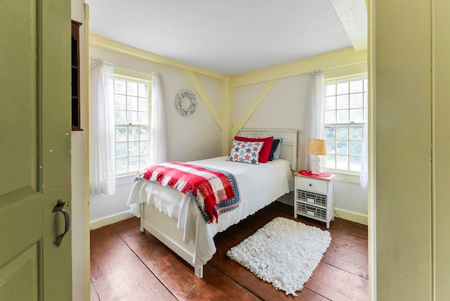 bedroom featuring dark hardwood / wood-style flooring and multiple windows