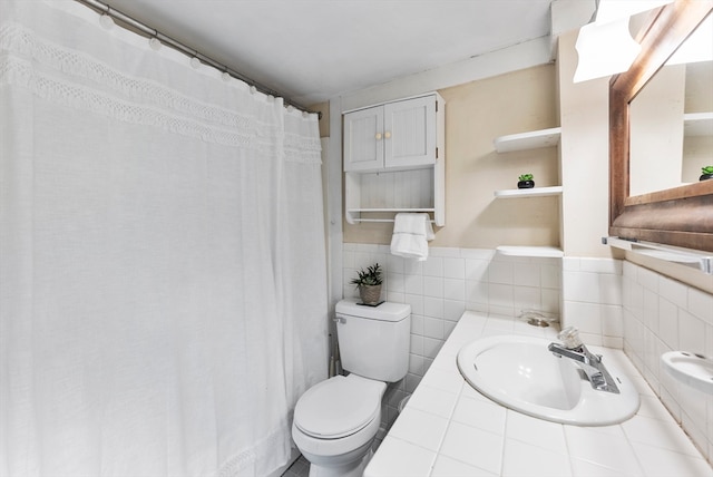 bathroom featuring sink, tile walls, and toilet