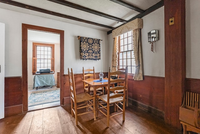 dining space with beam ceiling, hardwood / wood-style flooring, and plenty of natural light