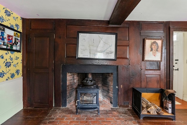 living room featuring beamed ceiling and a wood stove