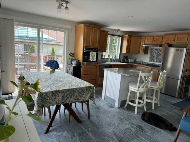 kitchen with a kitchen bar, a center island, black appliances, and sink