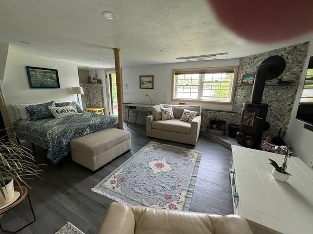 bedroom featuring dark hardwood / wood-style flooring and a wood stove