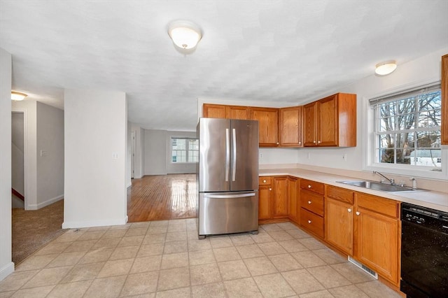 kitchen featuring stainless steel fridge, sink, and black dishwasher