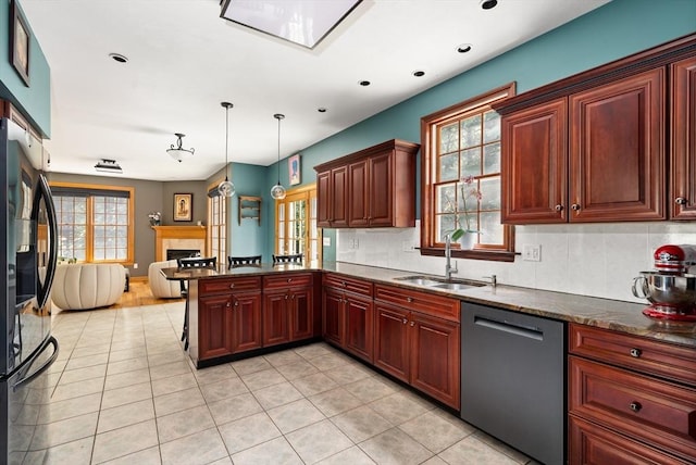 294 Cardinal Way, Northampton, MA 01062 - kitchen featuring stainless steel dishwasher, a fireplace, freestanding refrigerator, a peninsula, and light tile patterned flooring