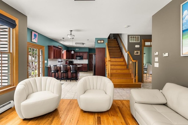 294 Cardinal Way, Northampton, MA 01062 - living area with a baseboard heating unit, stairway, and light wood-style flooring