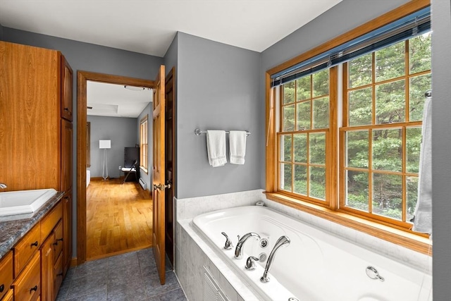 294 Cardinal Way, Northampton, MA 01062 - full bath with healthy amount of natural light, a jetted tub, vanity, and tile patterned floors