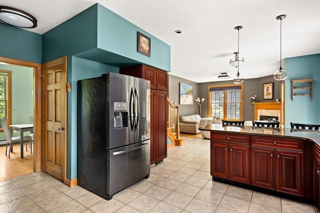 294 Cardinal Way, Northampton, MA 01062 - kitchen with stainless steel fridge, light tile patterned floors, pendant lighting, a fireplace, and reddish brown cabinets