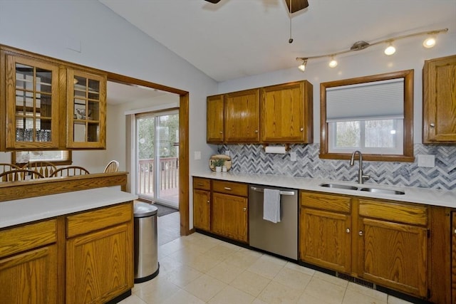 kitchen featuring a ceiling fan, lofted ceiling, a sink, light countertops, and stainless steel dishwasher