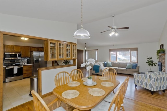 dining area featuring lofted ceiling, light wood-style floors, and ceiling fan