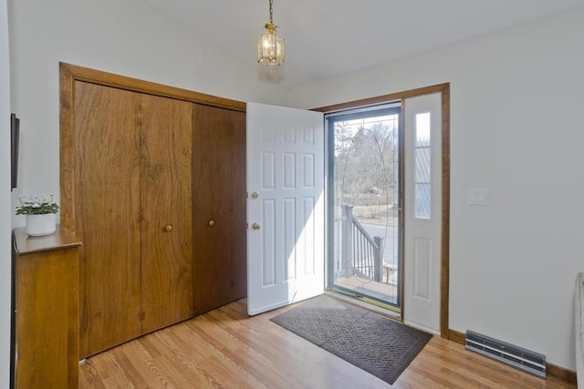 foyer entrance featuring visible vents, baseboards, and light wood-style flooring