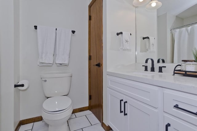 bathroom featuring tile patterned flooring, toilet, vanity, and baseboards