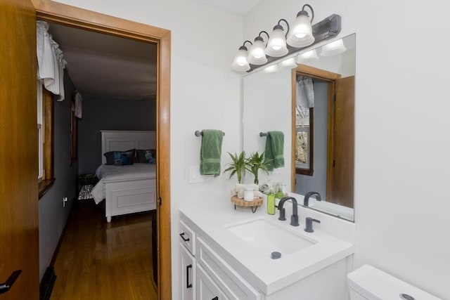 bathroom with vanity, toilet, and wood finished floors