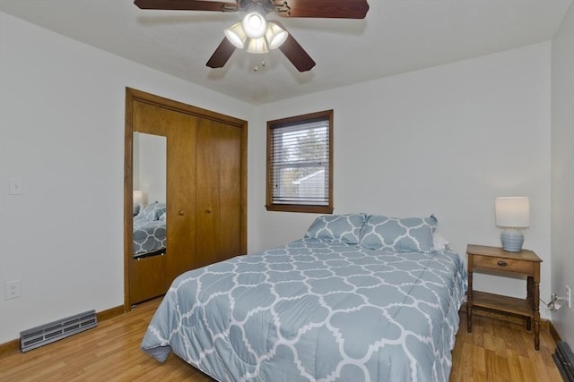 bedroom featuring a ceiling fan, baseboards, a closet, and light wood finished floors