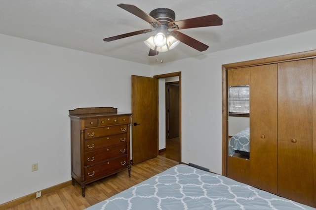 bedroom with a closet, ceiling fan, light wood-type flooring, and baseboards